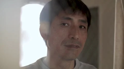 Sad looking middle aged guy turn to look at the camera and smile. Stock Footage 224906479