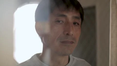 Sad looking middle aged guy turn to look at the camera. Asian male in 50s. Stock Footage 224906536