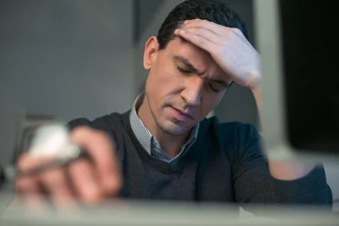 Sad male programmer experiencing headache Stock Photos