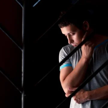 Sad man behind bars thinking about something Stock Photos