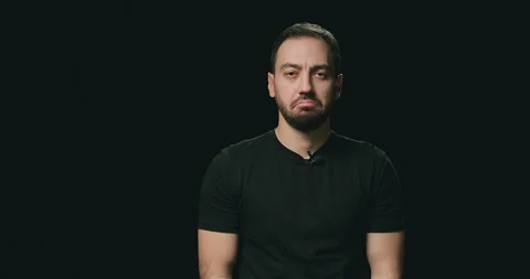 Sad man on black studio background. Feeling hopelessness, loneliness, bad Stock Footage 254112087