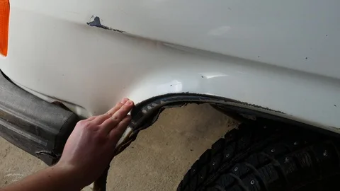 Sad man car owner touching dent from damage on body auto on automobile parking Stock Footage 128247357