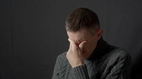 A sad man cries closing his eyes and wiping tears on his face  Stock Footage 170326069