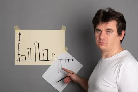 Sad man draws a graph with a drop down. Schedule of economic decline. Financi Stock Photos