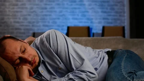 Sad man face lying on sofa at home Video stock 149137687