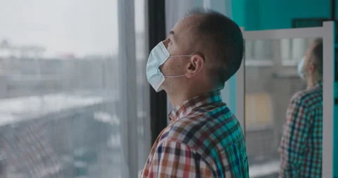 Sad Man In Face Mask Looking Through Window Stock Footage 145084771