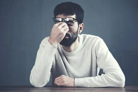 Sad man in formal clothes touching his nose Stock Photos