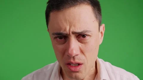 Sad man on green screen background struggling not to cry Stock Footage 308840227