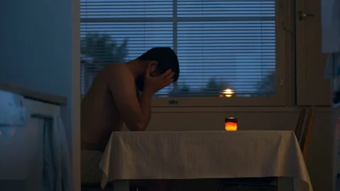 Sad Man In Grief Alone at Kitchen Table Late at Night, Insomnia and Video stock 156182977