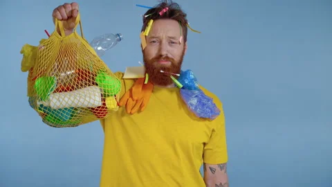 Sad man holding package with plastic trash and looking at the camera. Video stock 146227337