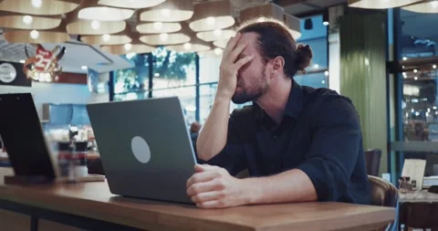 Sad man at laptop try to solve the problem sitting at coworking. Stressed Stock Footage 256915100