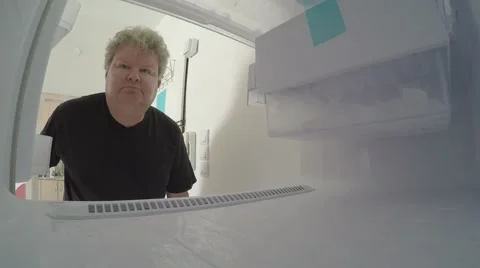A sad man looks inside empty freezer Видео 42788194