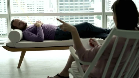 Sad man lying at couch and talking with therapist, 4K Видео 99844246
