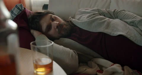 Sad man lying, thinking about harm of alcohol and want to change his bad habit Vídeos de archivo 238846218