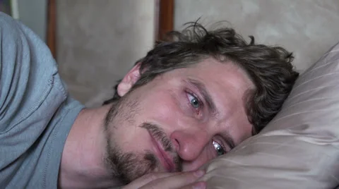 Sad man missing someone while laying in bed Stock Footage 32901185