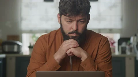 Sad man reading on a computer laptop screen Stockbeeldmateriaal 195984048