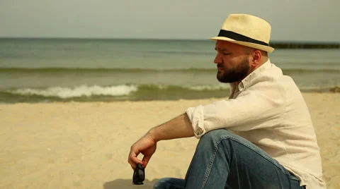 Sad man sits at the beach Stock Footage 63373080