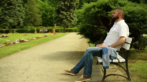 Sad man sits on a bench at the park Stock Footage 64283835