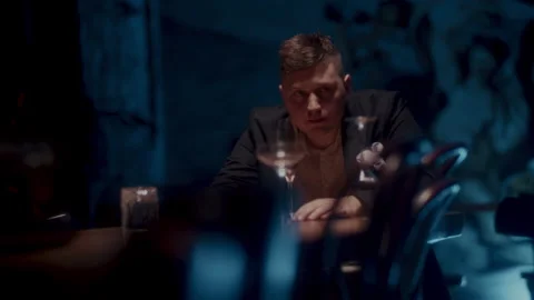 A sad man sitting alone at the table and looking around Stock Footage 258333243