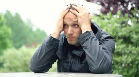 Sad man sitting by the table, outdoors, dolly shot HD Stock Footage 7135923