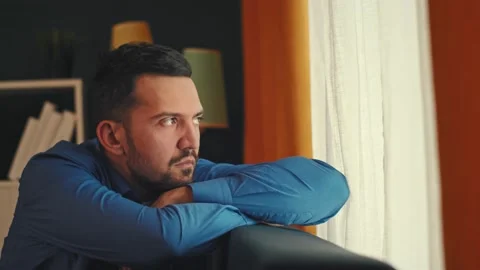 Sad man sitting on windowsill Stock Footage 168361227