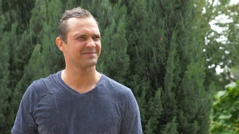 Sad man standing in the rain, slow motion. drops of rain flow down the face of a Stock Footage 91887891