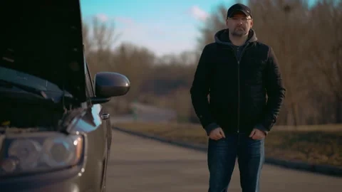 Sad man standing on road by broken car w... | Stock Video | Pond5