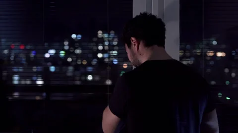 Sad man standing by the window at night and crying Stock Footage 297048575