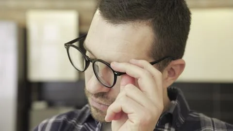 Sad man taking break while taking off glasses and putting on again. Slow motion Stock Photos