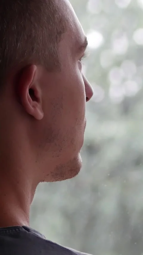 A Sad Man Thinking while Looking at the Rain from the Window Stock Footage 285842835