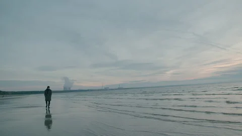 Sad man walk alone on the empty cold beach at the sunset Stock Footage 143253163