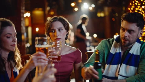 Sad millennials watching sport game on TV in dark bar closeup. Upset friends Stock Footage 334035897