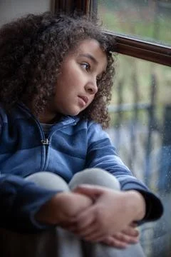 Sad Mixed Race African American Girl Looking Out of a Window Stock Photos