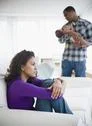 Sad mother with father holding baby in background Stock Photos