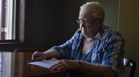 Sad old elderly man in retirment pondering letter at table Stock Footage 67340526