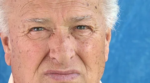 Sad old man closeup tilting portrait: pensive old man looking in camera Stock Footage 64305509