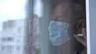 Sad Old Man In Mask Looks Outside Window View Through Glass Stock Footage