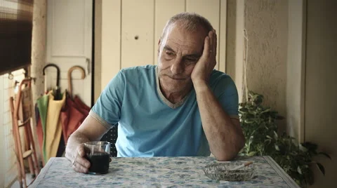 Sad old man sitting deep in his trouble: drinking red wine to forget problems Stock Footage 41757777