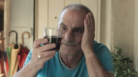 Sad old man sitting deep in his trouble: drinking red wine to forget problems Stock Footage 41757799
