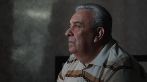 Sad overweight gray-haired elderly man in a dark room, close-up Stock Footage 254900469