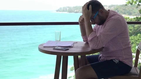 Sad, overwhelmed man reading bills sitting on terrace  Vídeo Stock 78905042