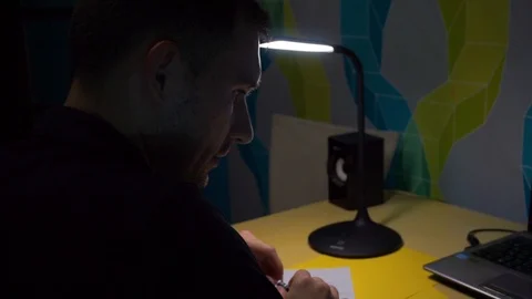 Sad, pensive guy thinks what to write in a letter, twists a pen in his hands Stock Footage 121644529