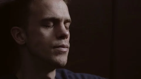 Sad pensive hamdsome man alone in the dark crying.Thoughts,worries,sadness Stock Footage 103514566