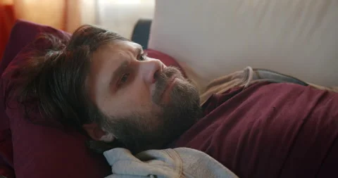 Sad, pensive man on couch. Thinking, upset, unshaven beard Stock Footage 238880755