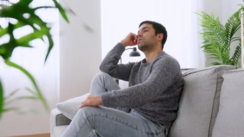 Sad pensive man sitting on sofa. Stock Footage 261468402