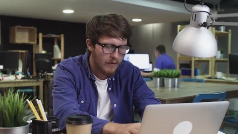 Sad programmer working on computer in office Stock Footage 129911923