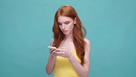 Sad redhead lady using smartphone isolated Stock Footage
