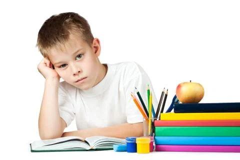 Sad schoolboy is doing his homework Stock Photos