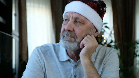 Sad serios beared senior man in red christmas hat looking to the side Stock Footage 144873589
