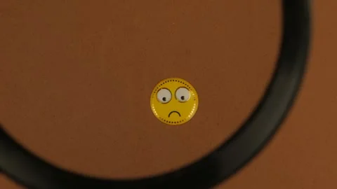 Sad Smiley Face Under Magnifying Glass Stock Footage 303267980